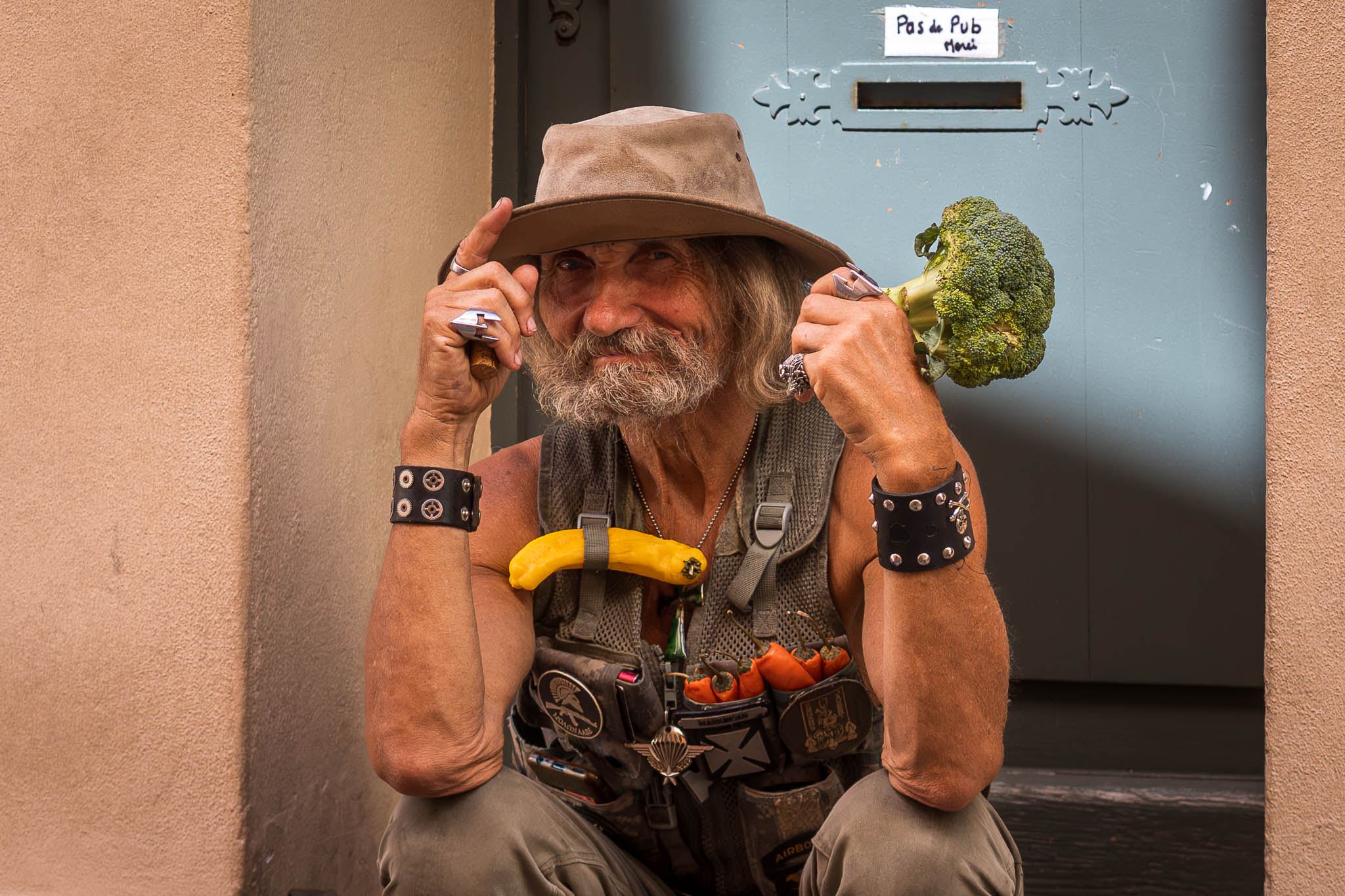 St Tropez Street Portrait eines alten Mannes mit schelmischen Lächeln und einem Brokkoli in der Hand